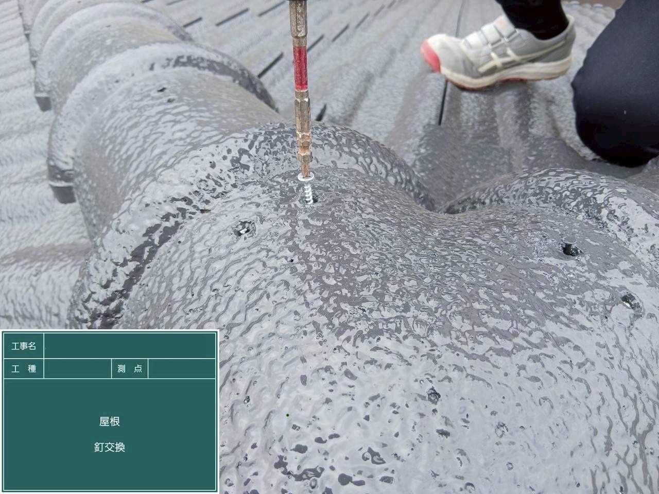 棟瓦の釘を抜いた穴にビスを打ち込んでいる